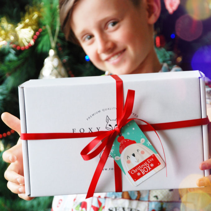 Boy holding FOXY BOXY Christmas Eve gift box