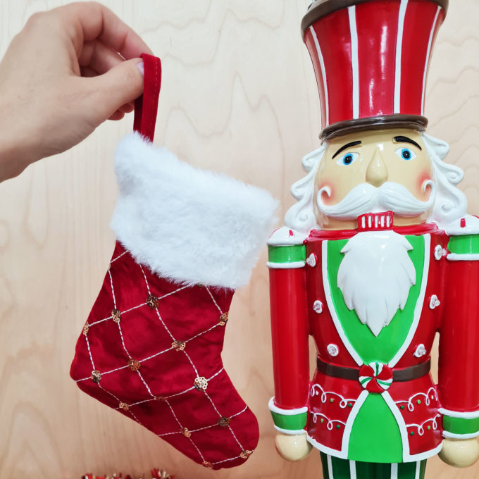 Christmas stocking being held up next to Xmas nutcracker