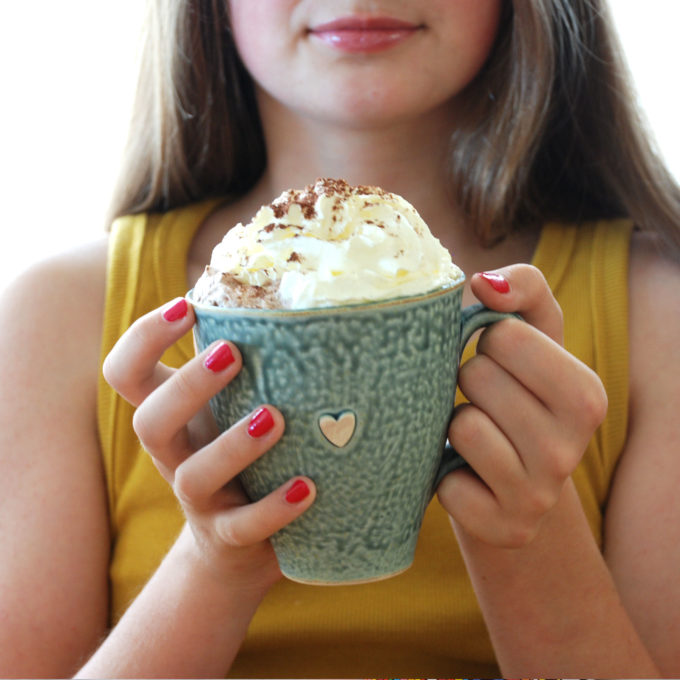Female holding Royce McGlashen heart mug with hot chocolate